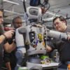 Ingenieure montieren Komponenten des humanoiden Roboters Atlas von Boston Dynamics in einer Werkstatt.