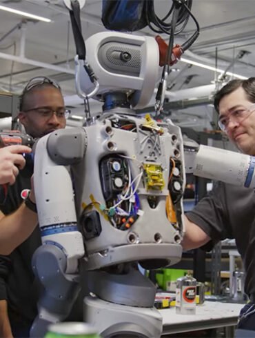 Ingenieure montieren Komponenten des humanoiden Roboters Atlas von Boston Dynamics in einer Werkstatt.