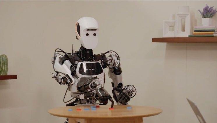Genie 4 simuliert einen humanoiden Apptronik-Apollo-Roboter beim Damespiel in einer KI-generierten Umgebung.